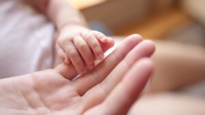 baby holding mother's hand
