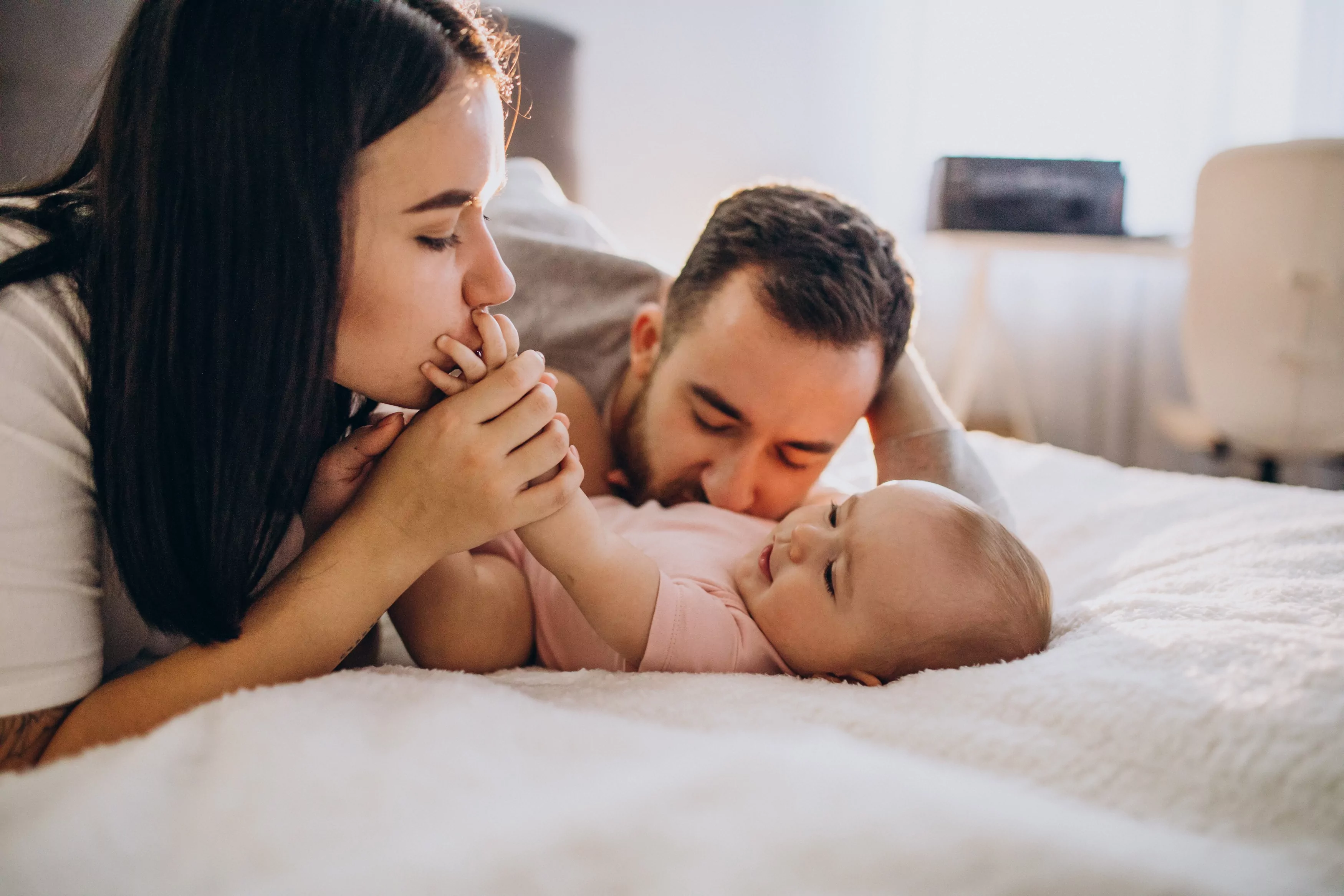 Young Family With Baby Daughter Lying Together Bed 1.Jpg