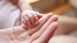 baby holding mother's hand